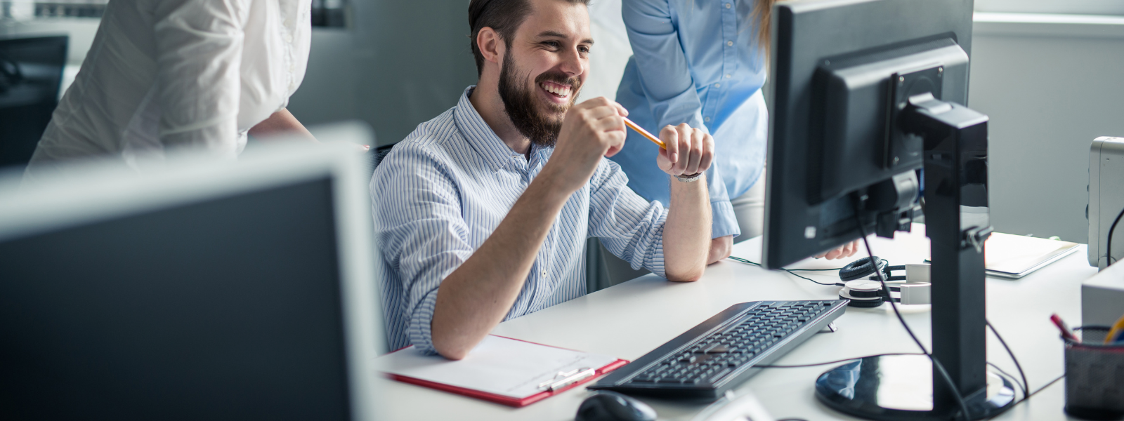 Healthy Home & Office - Person sitting at a desk with a computer and office supplies, smiling.