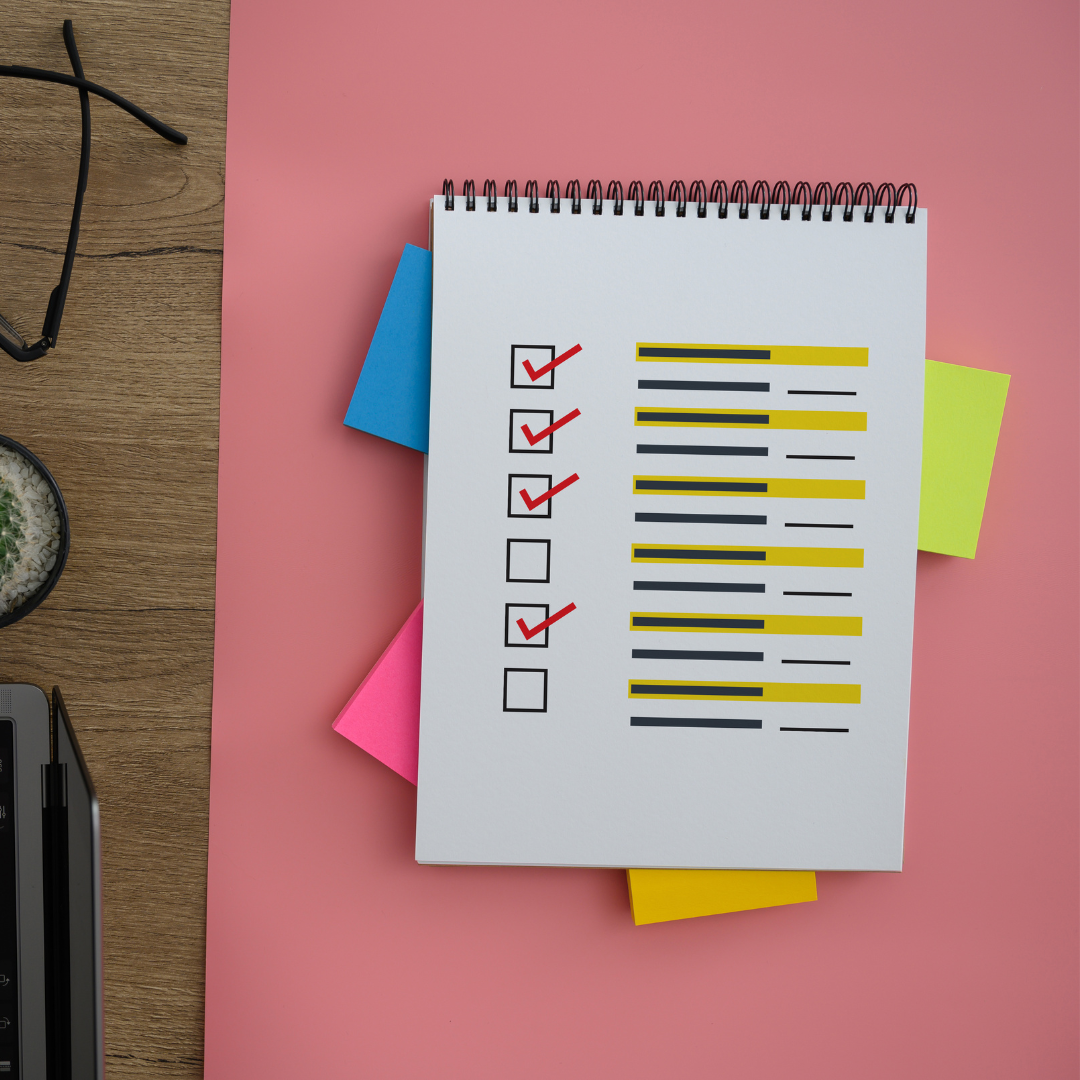Healthy Home & Office - Notebook with checklists and colourful flags on a pink surface