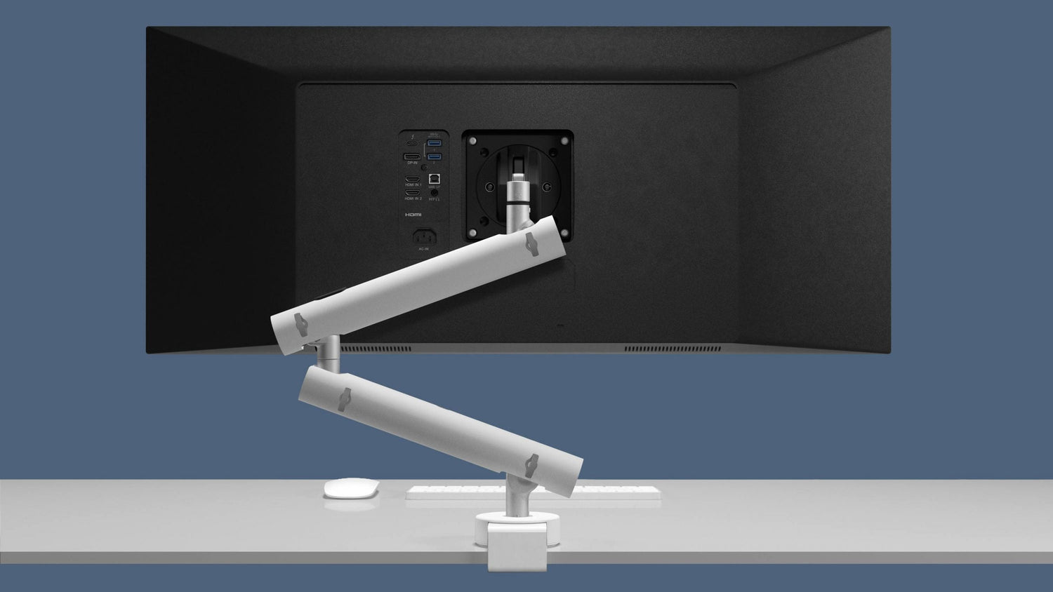 Black computer monitor with white monitor arms on a gray surface against a blue background